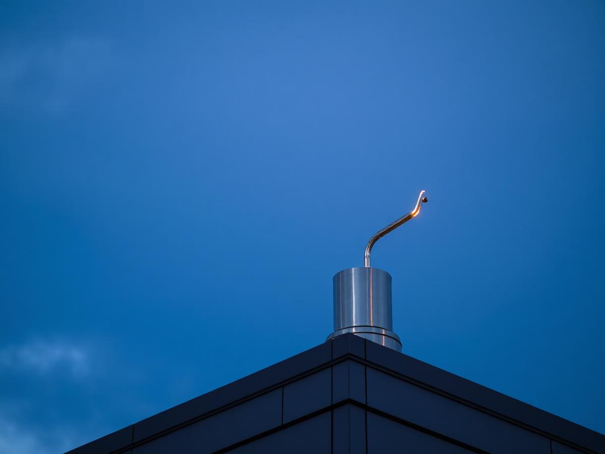 Haste de captação de para-raios instalada no topo de um edifício ao anoitecer